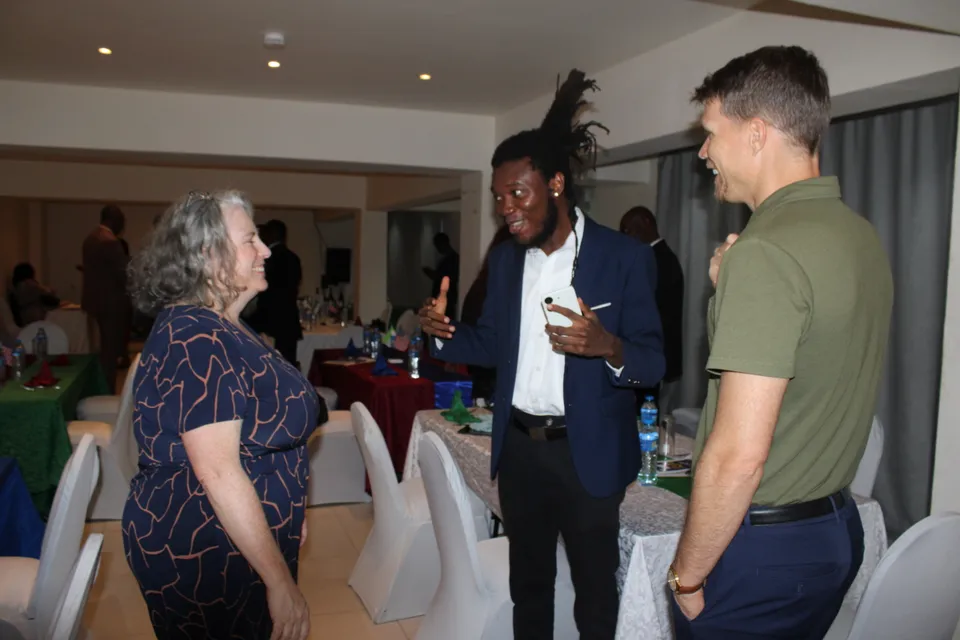 Joseph Jawah Kebbie speaks with Meghan Moore and Steven Grudda during the business dinner.