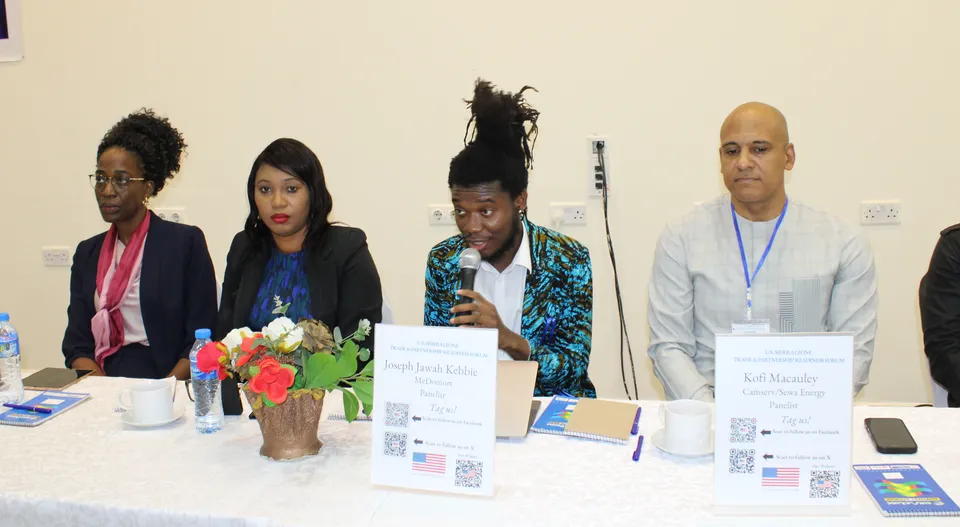 Joseph Jawah Kebbie speaking into a microphone alongside fellow panelists at the U.S.-Sierra Leone Trade & Partnership Readiness Forum.