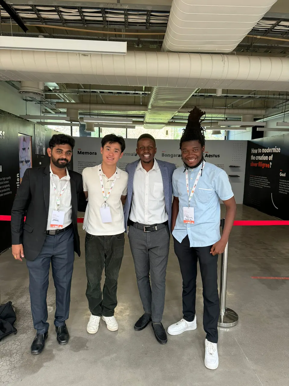 Four congress participants smiling together in an exhibition space.